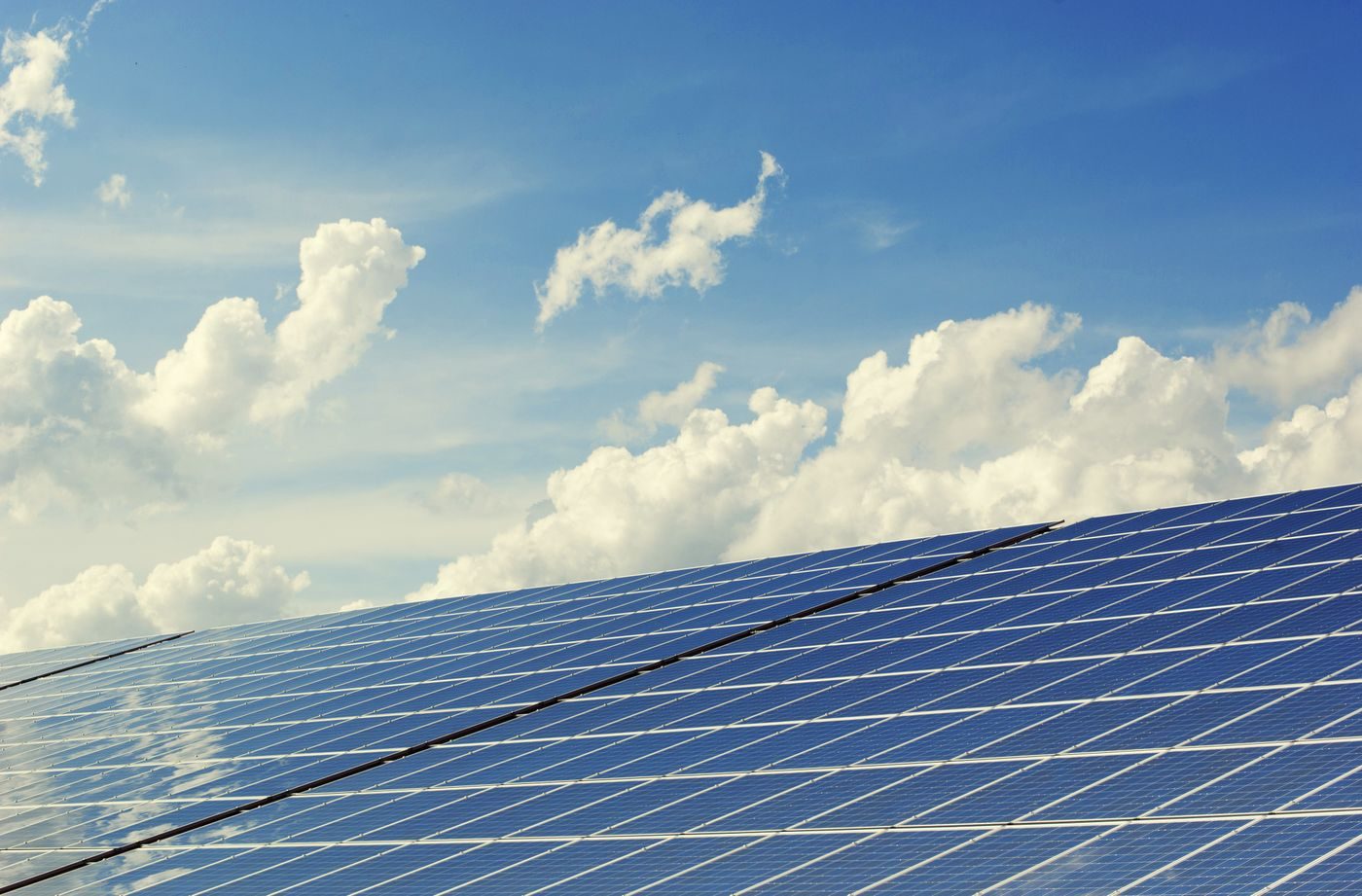 Solceller på tag mod blå himmel